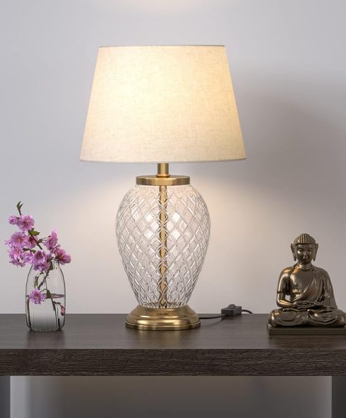 Elegant diamond-cut lamps with glass base, brass accents, and fabric shade placed on a wooden table