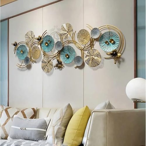 Stylish blue and gold metal wall décor with lotus leaf and geometric accents mounted above a sofa in a contemporary living room.