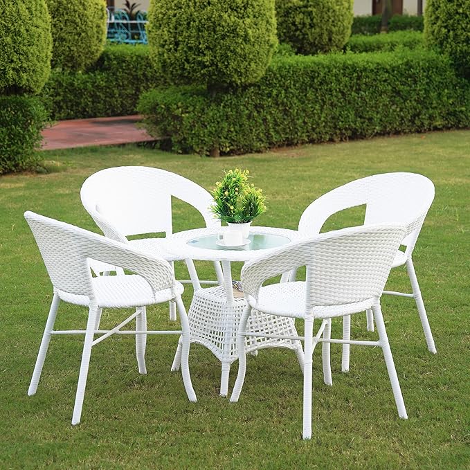 Elegant white rattan garden furniture set with four chairs and a glass-top table placed on a green lawn, perfect for outdoor dining and relaxation.