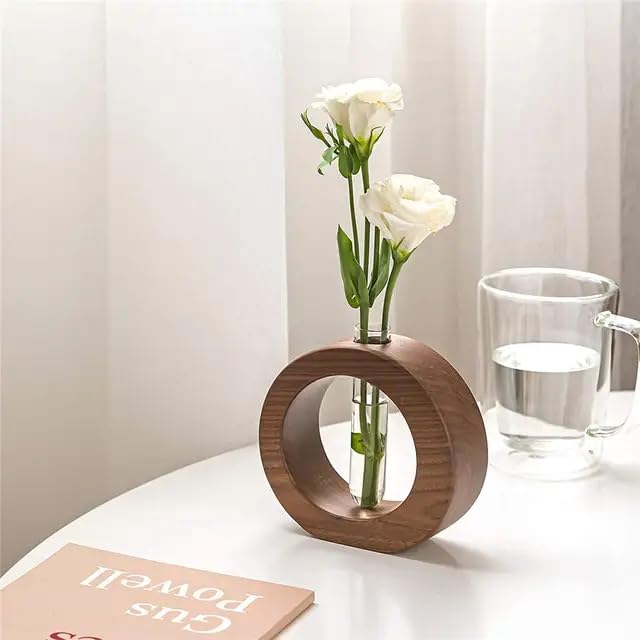 Wooden circular modern flower vase with glass tube holding white roses, minimalist table décor.