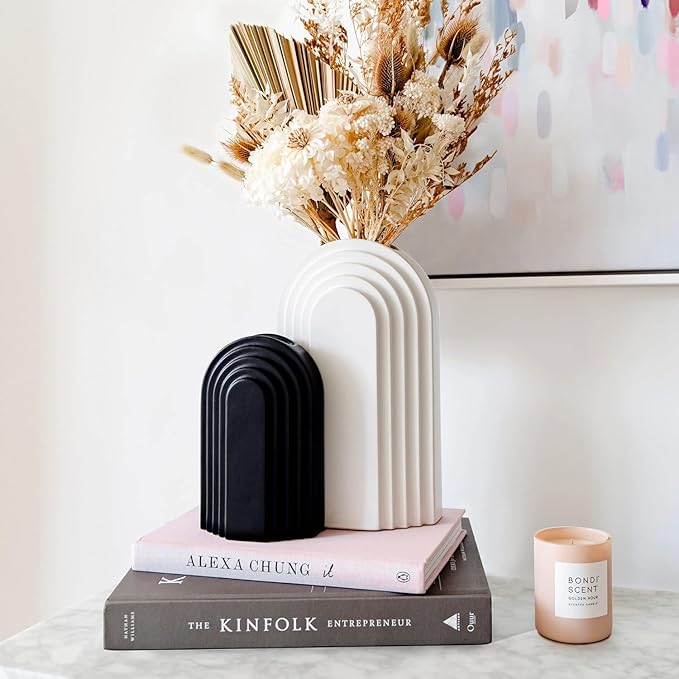 Black and white ceramic arched shape vases styled with dried flowers, modern minimalist home décor.