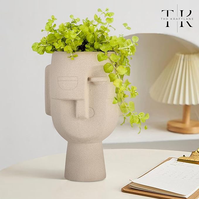 Ceramic Human Face Vase in beige finish with green plant, modern artistic home décor piece.