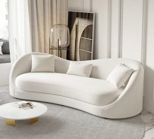 A modern white curved sofa, also known as a circle sofa couch, in a bright and minimalist living room.