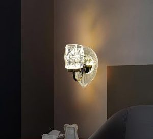 A decorative crystal wall sconce fixture with an illuminated LED Wall Lights, casting a warm light in a modern bedroom setting.